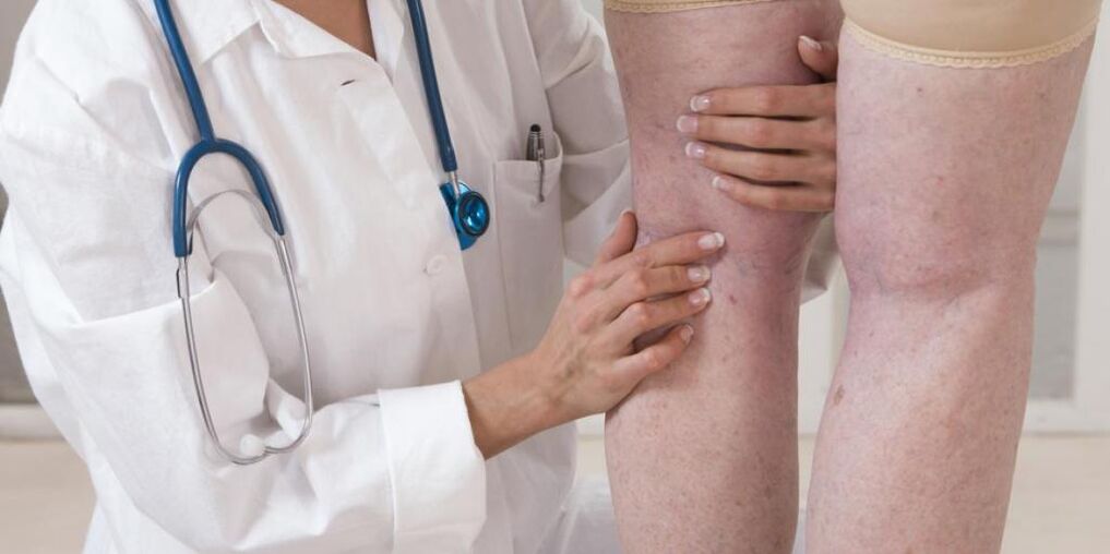 Der Arzt untersucht die Beine des Patienten